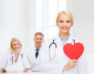 smiling female doctor with heart and stethoscope
